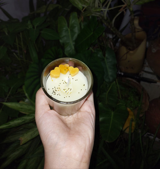 Hand-poured soy candle with yellow and white swirl, heart-shaped wax melts, and glitter décor